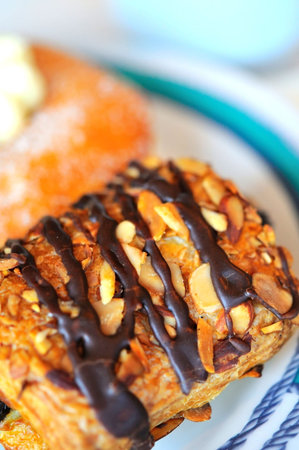 Freshly baked chocolate danish on white plate.の写真素材