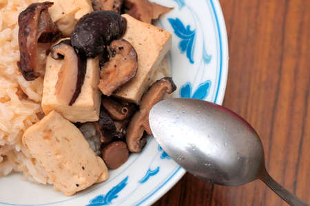 Simple but tasty dish of white bean curd and black mushrooms cooked Asian style.の写真素材