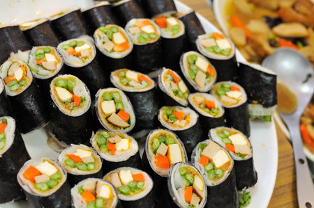 Rows of Japanese vegetarian sushi with vegetable and egg ingredients.の写真素材