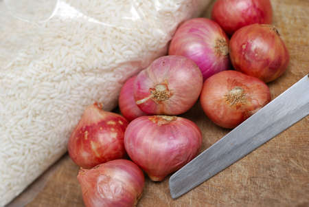 Fresh onions and knife on cutting board.の写真素材