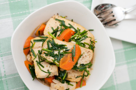 Oriental style stir fried tofu delicacy topped with carrots and spring onion oil.の写真素材