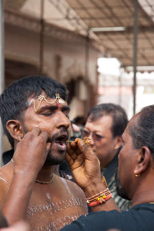 SINGAPORE - JANUARY 30: Piercings carried out on mouth of devotee during Thaipusam taken on January 30, 2010 in Singapore.のeditorial素材