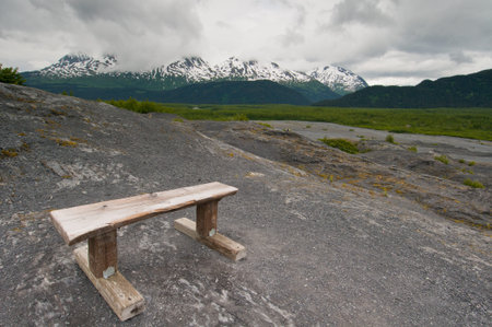Wooden bench on mountain overlooking majestic landscape.の写真素材
