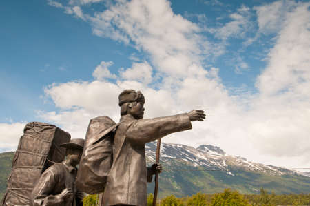 Bronze statues depicting concept of moving forward, progress, determination and success with mountain background.の写真素材