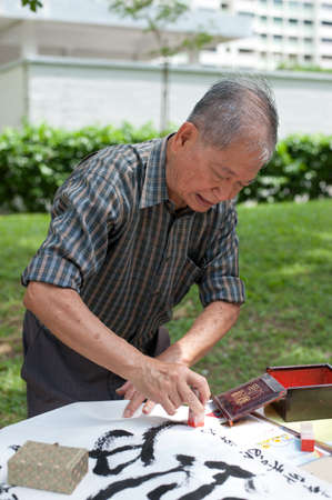 Calligrapher master Cai Zhuonan signing off on his work.のeditorial素材
