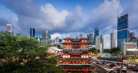 Asian temple lighted up against a modern skyline backdrop in Singapore.