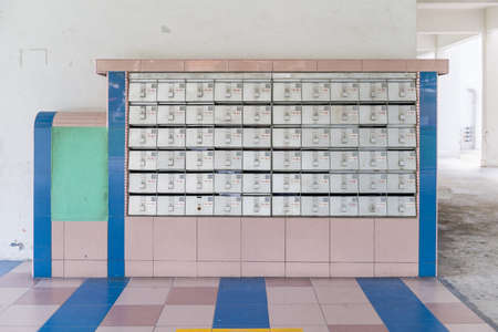 Rusty letter boxes or mail boxes with some containing letters in them. Communication, technology concepts.の写真素材