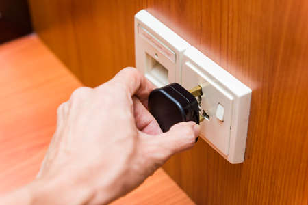 Hand plugging in power plug into socket. Energy concepts.の写真素材