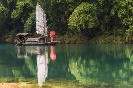 Chongqing, China, 18 Nov 2012: Chinese lady on traditional boat along scenic river in Three Gorges.のeditorial素材