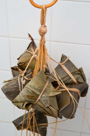 A bunch of delicious looking Oriental dumplings wrapped in bamboo leaves.の写真素材