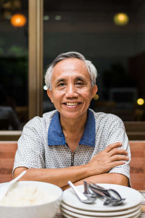 Smiling happy Asian male senior looking at camera.の写真素材