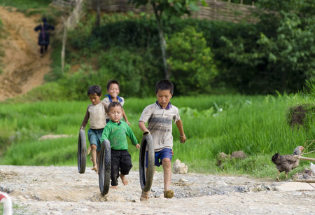 SAPA, VIETNAM - JULY 6: unidentified hilltribe boys enjoy tire-spinning competition July 6, 2009 in Sapa, Vietnam. Sapa is a frontier town where many ethnic minority groups live.のeditorial素材