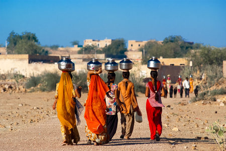 RAJASTHAN, INDIA â FEB 27  women lugging a water pot on their head on February 27, 2013 in Rajasthan, India  Due to the lack of piped water, poor tribals have to fetch water from its natural sources のeditorial素材