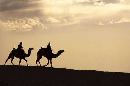 JAISALMER, INDIA - FEB 26    Two cameleers go through the sand dune in Thar Desert, on Feb 26, 2013 in Jaisalmer, India   Camel riding activity is another income source for desert villagers apart from farming and animal raisingのeditorial素材