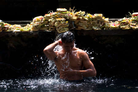 BALI, INDONESIA â MAY 6  a man takes a bath at the Tirta Empul Temple on May 6, 2013 in Bali, Indonesia  It is believed that the water is holy and can bring good health and good luck のeditorial素材