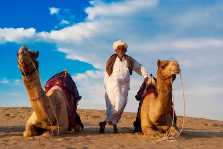 JAISALMER, INDIA - FEB 26   Cameleer and his herd at the Sam Sand Dune on Feb 26, 2013 in Jaisalmer, India   Camel riding activity for tourists is another income source for desert villagers apart from farming and animal raisingのeditorial素材