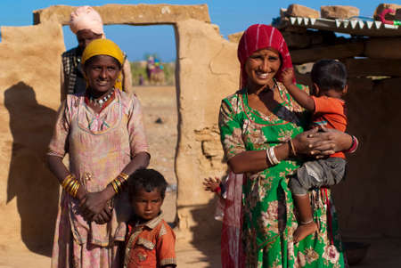 RAJASTHAN, INDIA â FEB 27  Rajasthani family in front of their mud hut on February 27, 2013 in Jaisalmer, India  There are many tribes in Rajasthan with the differences in costumes, jewellery etc のeditorial素材