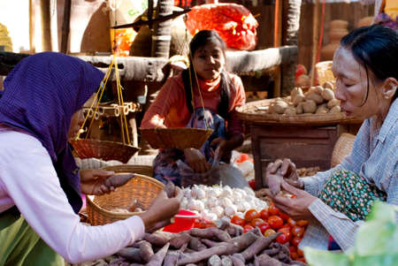 NYAUNG-U,MYANMAR-FEBRUARY 14  Unidentified girl sets up vegetable stall on February 14, 2011 at Nyaung-U market,Myanmar  It is a local market where people come from all over the area to sell products のeditorial素材