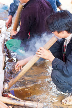 BAC HA MARKET, VIETNAM - JULY 5: a man tastes tobacco at Bac Ha market on July 5, 2009 in Lao Cai, Vietnam. Bac Ha is hilltribe market where hilltribe people come to trade for goodsのeditorial素材