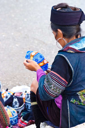 SAPA, VIETNAM - JULY 7: Hill tribal vendor on Sapa's main street on July 7, 2009, Sapa, Vietnam.  Since the advent of tourism in Sapa, minority people earn their living by selling their farming produce or handcraft to tourists.のeditorial素材