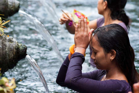 BALI, INDONESIA â MAY 6  Worshippers make an offering at the Tirta Empul Temple on May 6, 2013 in Bali, Indonesia  They believe that water from the spring is holy and has the healing power のeditorial素材