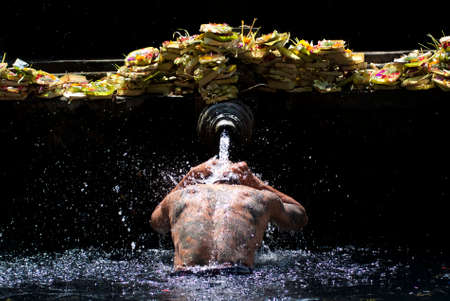 BALI, INDONESIA â MAY 6  a man takes a bath at the Tirta Empul Temple on May 6, 2013 in Bali, Indonesia  It is believed that the water is holy and can bring good health and good luck のeditorial素材