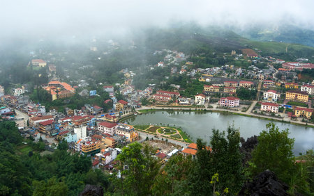Aerial view of clusters of buildings nestled in the green valley of Sapa, Vietnamの写真素材