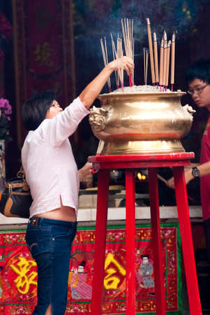 KUALA LUMPUR, MALAYSIA - FEBRUARY 18: Unidentified woman pays homage on February 18, 2012 at Guan Di Temple, Kuala Lumpur, Malaysia. Guan Di Temple or God of War Temple is one of the oldest Chinese temples in Kuala Lumpur.のeditorial素材