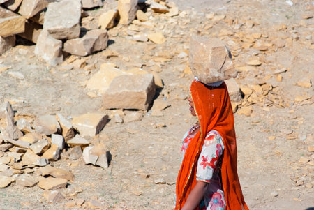 JAISALMER, INDIA - FEB 25  A woman carries a brick on her head on a construction site on Feb 25,...