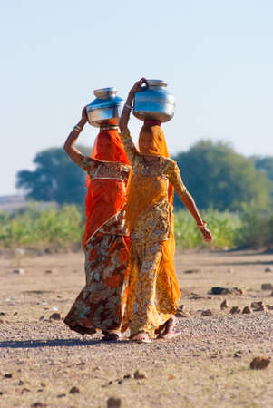 RAJASTHAN, INDIA â FEB 27  women lugging a water pot on their head on February 27, 2013 in Rajasthan, India  Due to the lack of piped water, poor tribals have to fetch water from its natural sources のeditorial素材