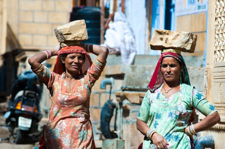 JAISALMER, INDIA - FEB 26  women carry a brick on their head on a construction site on Feb 26, 2013 in Jaisalmer, India  Construction is the third-largest employer of women in Indiaのeditorial素材