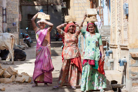 JAISALMER, INDIA - FEB 26  women carry a brick on their head on a construction site on Feb 26, 2013 in Jaisalmer, India  Construction is the third-largest employer of women in Indiaのeditorial素材