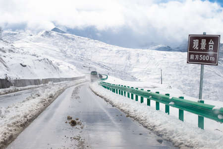 Snowcovered mountain and slippery road to Huanglong Chinaの写真素材