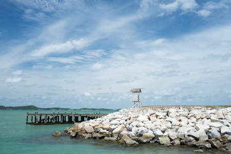 Seascape with a pier of rock foundation and lighthouse, Gulf of Thailandの写真素材
