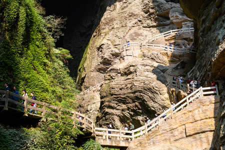 Tourists walk through the Longshuixia Fissure Gorge along the path that winds itself into the fissureのeditorial素材