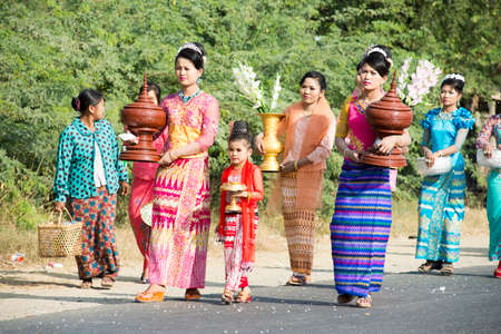 MANDALAY, MYANMAR - FEB 1: Women dressed in Burmese traditional costumes in a procession of  the novitiation ceremony on Feb 1, 2016.  The ceremonies are usually held during the summer when schools are closed for the year-end vacation.のeditorial素材