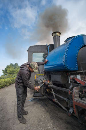 DARJEELING, INDIA â NOVEMBER 27, 2016: technician services the steam engine hauled DHR Toy Train used for joy ride tours as well as regular transport services in Darjeeling.のeditorial素材