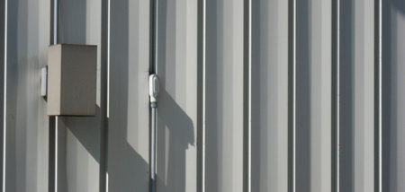 White building siding with a box on the side. Photograph shot to bring out modelling. Good texture