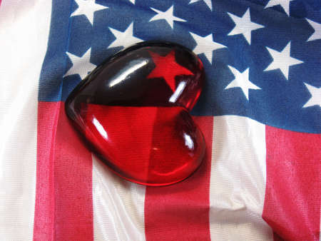 glass heart on American USA flag red white and blueの写真素材