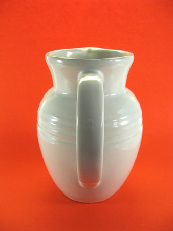 Plain white milk jug on orange backgroundの写真素材