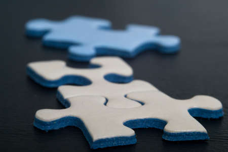 Jigsaw puzzle pieces on dark backgroundの写真素材