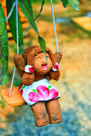 Clay doll woman sitting swings Smiling with pleasureの写真素材
