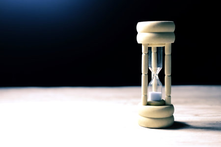 hourglass on the table with wasted time. time management.