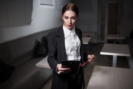business lady in suit and with red lips and with tablet;の写真素材
