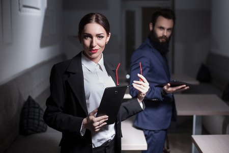dressed in suits business woman and man keep tablets;の写真素材