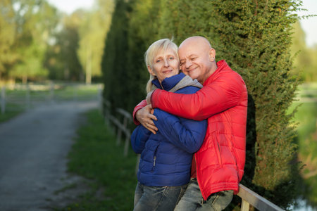 happy seniors couple embrace and smile; older male and female in park;の写真素材