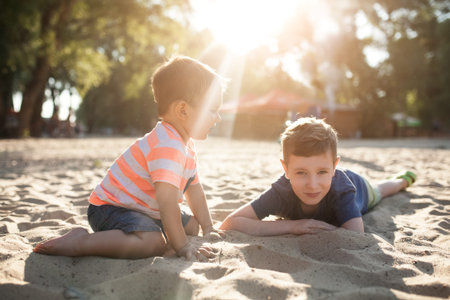 happy brothers smiling and sitting on ground;の写真素材