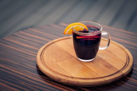 mulled wine on wooden board and with orange; alcohol glintwein with fruit on wood;の写真素材