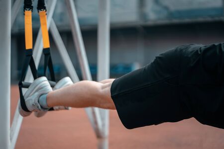 yound sporty athlete or bodybuilder has fitness workout with trx outdoorの写真素材