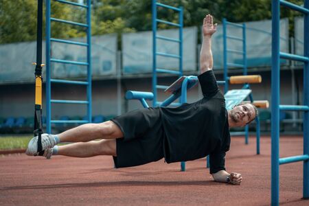 young sporty athlete or bodybuilder has fitness workout with trx outdoorの写真素材